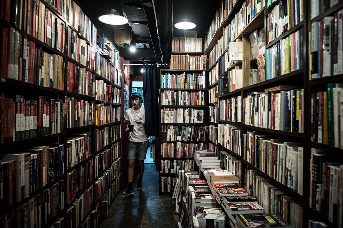 photo of a man standing in book stacks